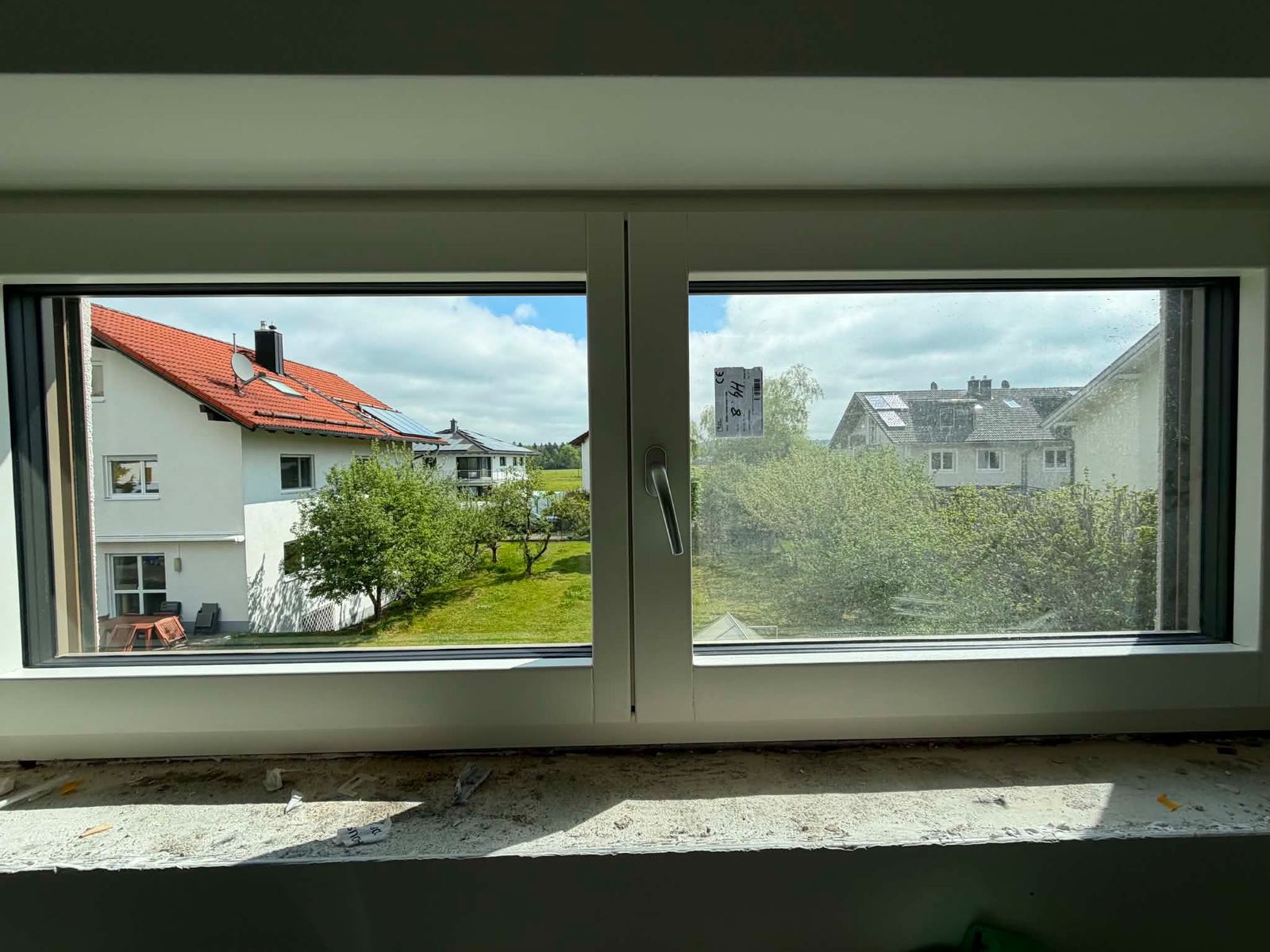 Fensterelement im Neubau nach der Glasreinigung, Fensterbank noch im Rohbauzustand